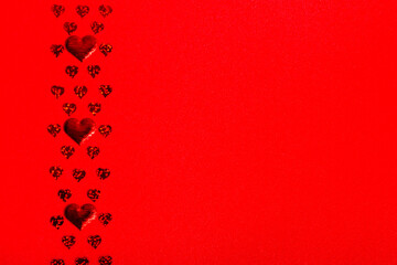 Red hearts of different sizes on a red textured background. Valentine's Day and Mother's Day festive banner  copy space