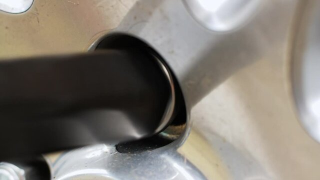 Close-up of a car wheel nut being tightened with a special tool at a car service center 