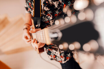 Musician playing electric guitar at home studio. Close up of hand practicing with music instrument.