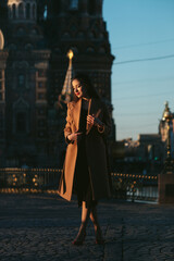 Obraz premium girl in coat in the street at sunrise