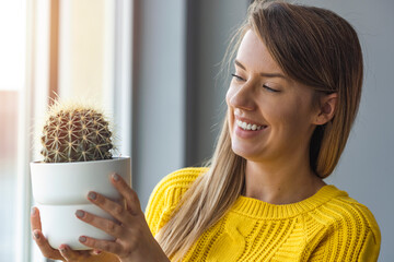 Woman holding flowerpot with green cactus. environment protection and activism. Gardening and...