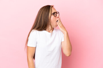 Young English woman isolated on pink background yawning and covering wide open mouth with hand