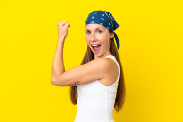 Young English woman isolated on yellow background doing strong gesture