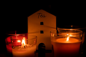 Red candle burning in dark with focus on single candle in foreground.