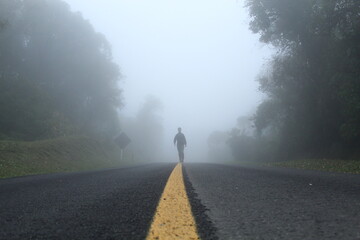 homem caminhando em estrada com neblina -  na Estrada da graciosa, Paraná