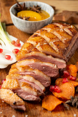 Aerial view of duck breast with chives and peaches, on table and table, selective focus, vertical