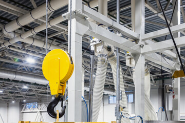 Crane hook inside factory building, industrial background