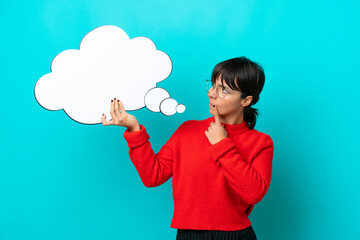 Young woman isolated on blue background holding a thinking speech bubble