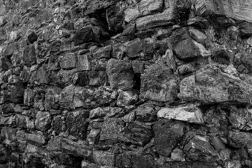 Grungy cragged bumpy pitted cavity stone facade, split layer gap.Ruined cracked shattered worn rough hiking canyon.Old ragged grunge steep marble cliff. Grand vintage crannied damaged impressive gorge