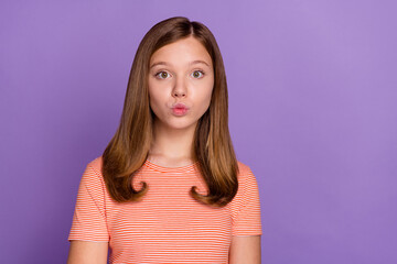 Fototapeta premium Portrait of attractive affectionate funky brown-haired girl sending air kiss isolated over vibrant violet purple color background