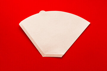 Bleached paper coffee filter for immersion brewing isolated on a colored pink background....