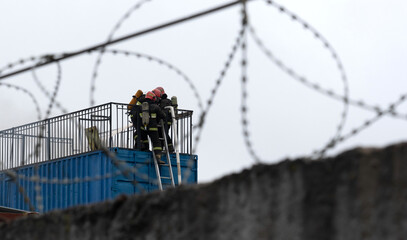 Firefighters extinguish a fire in a warehouse.