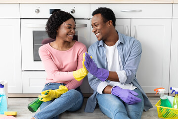 Satisfied black man and woman house-keepers giving high five