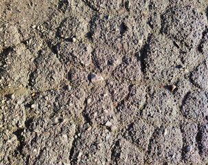 Old cracked asphalt with dirt and small stones