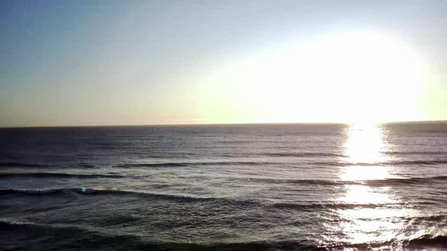 playa con olas desde drone plano aereo subiendo hacia el cielo
