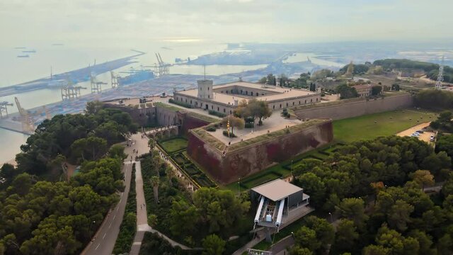 Aerial drone view of Barcelona, Spain. Montjuic Castle with tourists, a lot of greenery, sea port on the background