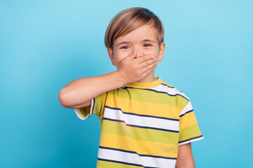 Portrait of attractive cheerful boy laughing closing mouth oops isolated over bright blue color background