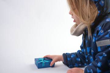 dressed for winter little girl pick up a blue gift box 