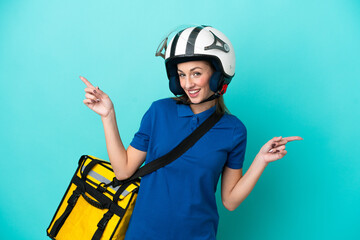 Young caucasian woman with thermal backpack isolated on white background pointing finger to the laterals and happy