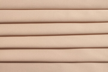 Fototapeta premium Silk atlas soft tender beige color fabric with waves folded macro