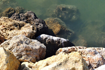 Close Up of Colourful Rocks and Water on Beach 