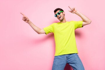 Portrait of attractive cheerful guy having fun dancing spending free time isolated over pink pastel color background