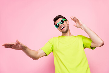 Photo of funky brunet hairdo millennial guy dance wear eyewear green t-shirt isolated on pink color...