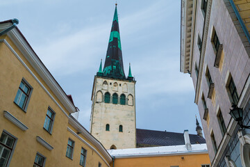 Low-angle view of apartment buildings and the tower of the Saint Olaf's Church in overcast winter...
