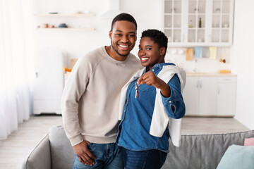 Happy black couple showing keys of their apartment