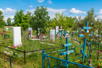 Wide shot of graves and trees in the Zaykovskoye Cemetery in sunny summer day, Kurgan, Russia
