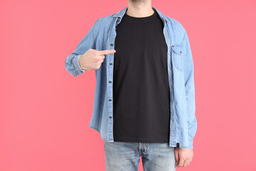 Man in blank black t-shirt on pink background