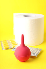 Concept of healthcare with hemorrhoids accessories on yellow background