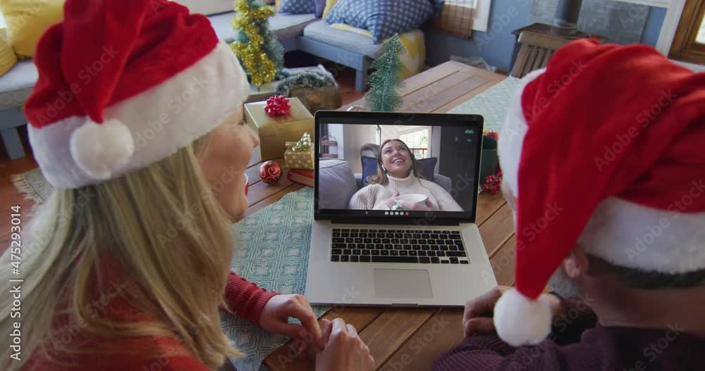 Sticker Caucasian couple with santa hats using laptop for christmas video call with woman on screen