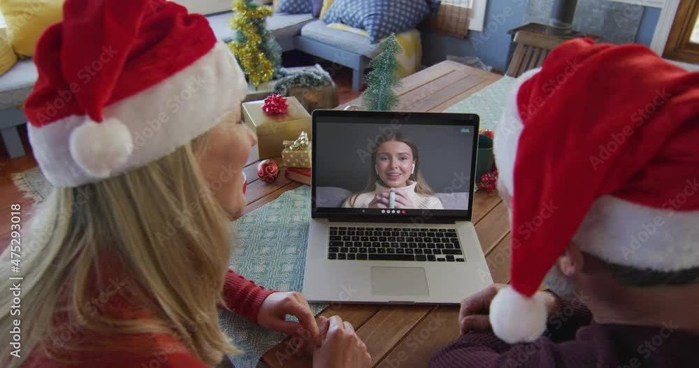 Sticker Caucasian couple with santa hats using laptop for christmas video call with woman on screen