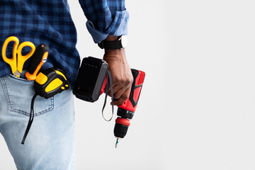 Men work concept. Black man holding screwdriver, with tools in pocket, white background with free...