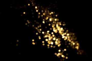 Golden blurred bokeh lights on black background. Glitter sparkle stars for celebrate. Overlay for your design