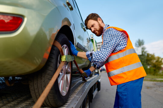 Tow Truck Operator Fixing Car On Platform