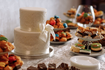 white wedding cake. Wedding cake detail - a ribbon with pearls. candybar.