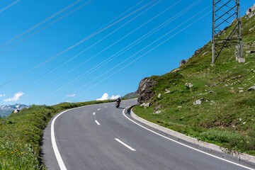 Fototapeta premium Power lines cross the Nufenenpass road near Ulrichen