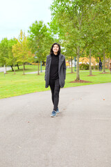 Biracial Asian teen girl enjoying fall autumn leaves along road