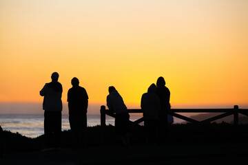 Fototapeta na wymiar Silhouette of people enjoying beautiful sunset off California coast