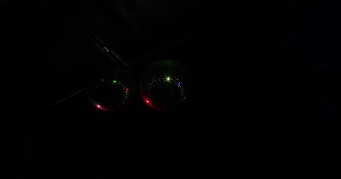 Two Disco Ball glitter ball reflects multi colored rays. Night club interior. Dark party background with copy space