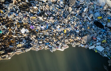 Aerial shot view waterfront scrap-heap pile plastic bottles rubbish outdoor. Pollution debris on...