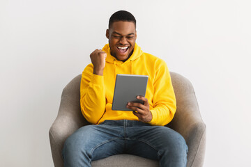Joyful African Guy Using Digital Tablet Gesturing Yes, Gray Background