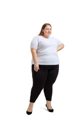 Full-length portrait of plus-size woman wearing white t-shirt and jeans posing isolated on white studio background. Body positive concept