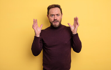 middle age handsome man looking shocked and astonished, with jaw dropped in surprise when realizing...