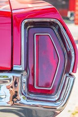 The red brake light or taillight of a red classic car or Muscle- Car