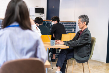カフェで仕事をする中年男性