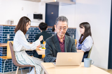 カフェで仕事をする中年男性