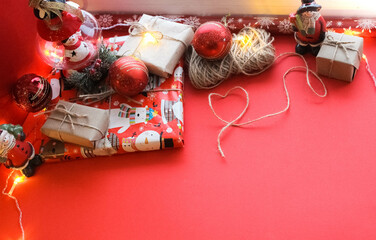 Christmas composition of gift in kraft paper on bright red background. Flat plan, top view, top lay, lay out, flat lay, top view, copy space. Christmas, winter, new year concept. Space for text